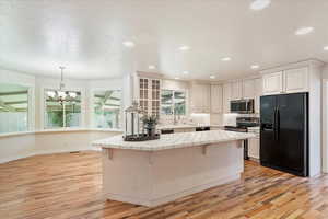 Kitchen with black appliances, tile counters, a chandelier, light wood finished floors, and recessed lighting