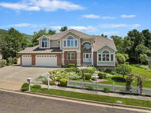 View of front facade with concrete driveway, brick siding, roof with shingles, a garage, and an attached garage