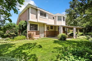 View of front of property featuring brick siding, stucco siding, and a front yard