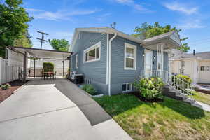 View of home's exterior featuring central AC unit, concrete driveway, and a carport