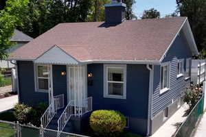 View of front of property featuring a chimney and roof with shingles