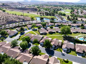 Aerial perspective of suburban area featuring a local golf course and a water and mountain view
