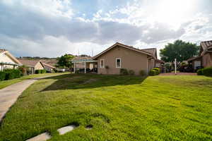 View of grassy yard featuring a pergola