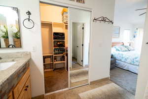 Bathroom featuring vanity, ensuite bath, ceiling fan, and lofted ceiling