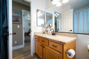Bathroom with vanity, a chandelier, and wood finished floors