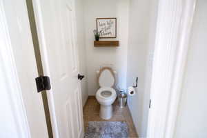 Bathroom with tile patterned flooring, toilet, and baseboards