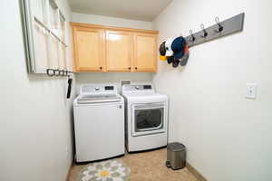 Washroom featuring independent washer and dryer, cabinet space, and baseboards