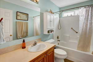 Full bath featuring vanity, shower / tub combo, and toilet
