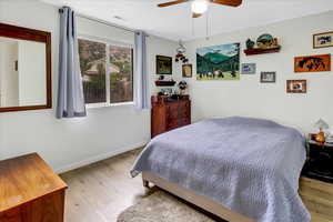 Bedroom with wood finished floors, baseboards, and ceiling fan