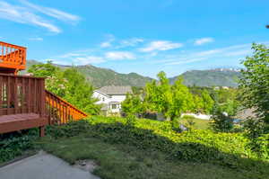 View of yard with a deck with mountain view