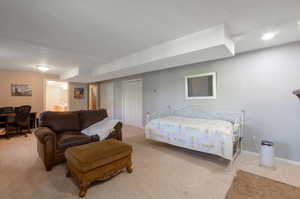 Bedroom featuring carpet floors, ensuite bath, and baseboards