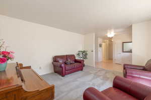Living area with light colored carpet and baseboards