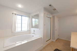Bathroom with vanity, a bath, a shower stall, tile patterned floors, and recessed lighting
