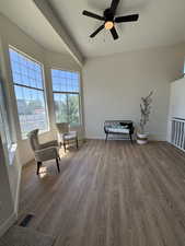 Living area with baseboards, dark wood-style flooring, and ceiling fan