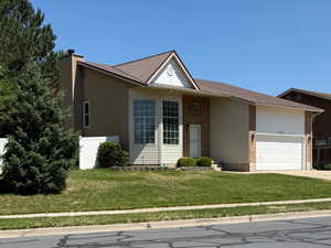 Ranch-style house with a garage, a front yard, brick siding, and driveway