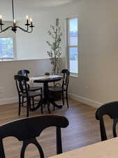 Dining space with plenty of natural light, a chandelier, baseboards, and a textured ceiling