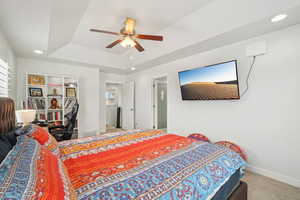 Primary suite featuring carpet flooring, a tray ceiling, baseboards, a ceiling fan, and recessed lighting