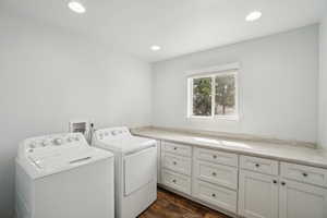 Laundry room featuring independent washer and dryer, recessed lighting, dark wood-style flooring, and cabinet space