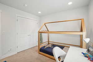 Carpeted bedroom featuring recessed lighting and a closet