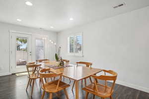 Dining area with healthy amount of natural light, baseboards, recessed lighting, and dark wood-style floors
