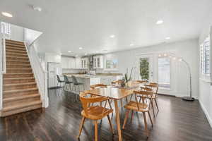 Dining room featuring dark wood finished floors, stairs, recessed lighting, and baseboards