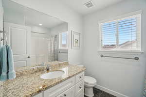 Full bathroom featuring toilet, vanity, a shower with shower curtain, tile patterned flooring, and baseboards