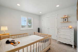 Bedroom featuring light colored carpet, a closet, and recessed lighting