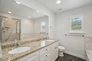 Primary Full bath featuring plenty of natural light, double vanity, a marble finish shower, toilet, and recessed lighting