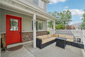 Property entrance with outdoor lounge area, stone siding, a mountain view, and covered porch