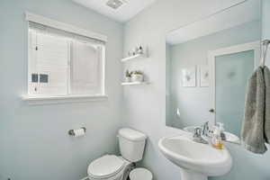 Half bath featuring toilet and a sink