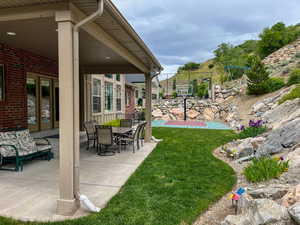 View of grassy yard with a patio area
