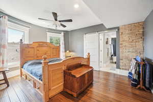 Bedroom with wood flooring, baseboards, ceiling fan, connected bathroom, and recessed lighting