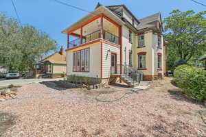 View of back of property featuring a balcony and central air condition units