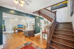 Living room featuring hardwood floors, stairs,  recessed lighting, and a chandelier