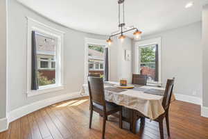 Dining room featuring plenty of natural light, historic baseboards, hardwood floors, and recessed lighting