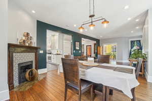 Dining space featuring recessed lighting, light wood-style flooring, baseboards, and a fireplace