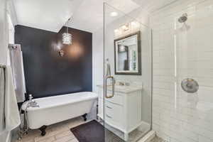 Full bath with a freestanding tub, vanity, and tile & glass shower
