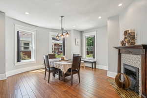 Dining room featuring a fireplace, baseboards, hardwood, and recessed lighting