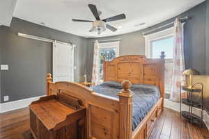 View toward windows in bedroom with huge closet behind barn door