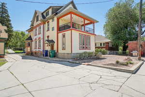 View of side of property featuring a balcony upstairs and enclosed porch on the main floor