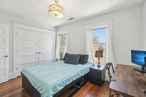 Bedroom featuring dark wood flooring and a large closet