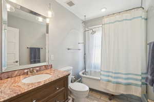 Bathroom with toilet, vanity, and shower / historic bathtub combination with curtain
