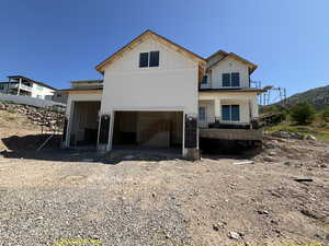 Back of property with board and batten siding, stairway, and a garage