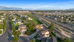 Aerial view of property and surrounding area featuring nearby suburban area and a mountain backdrop
