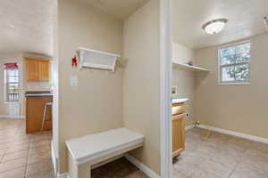Mudroom featuring light tile patterned flooring, plenty of natural light, and baseboards