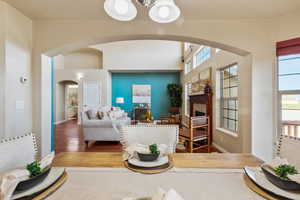 Living area featuring arched walkways, wood finished floors, a fireplace, and baseboards
