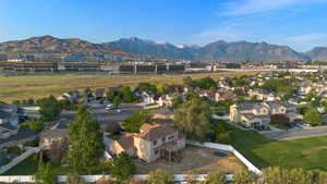 Aerial view of property and surrounding area with mountains and nearby suburban area