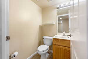Bathroom featuring vanity, toilet, tile patterned floors, and baseboards