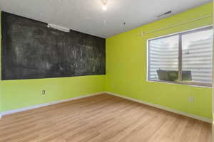 Spare room featuring wood finished floors and baseboards