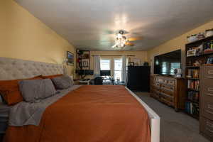 Carpeted bedroom featuring ceiling fan